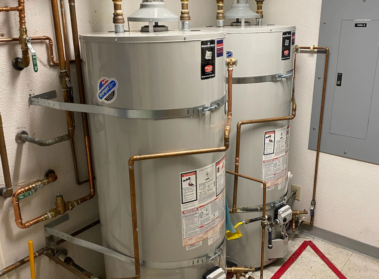 light grey water heater with some golden faucets